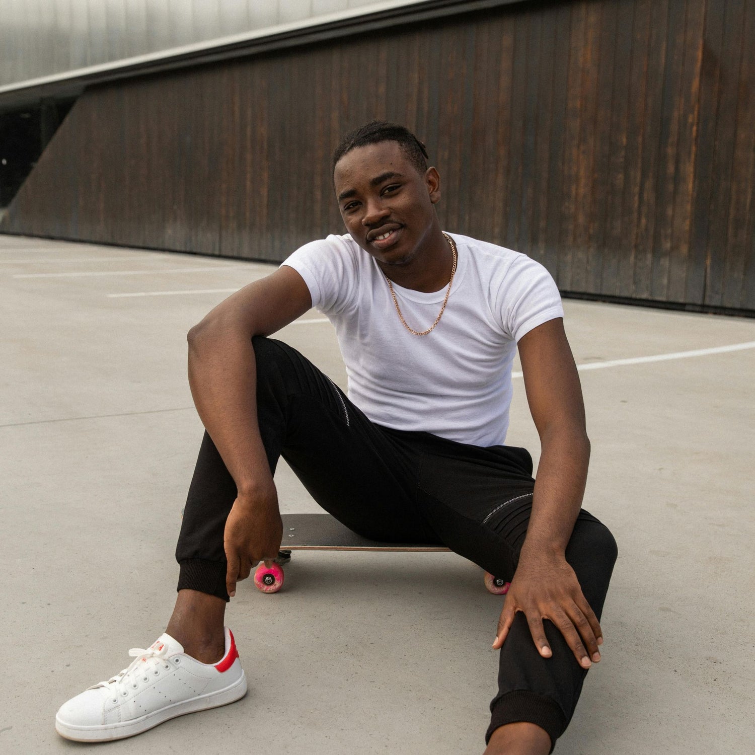 Person sitting on a skateboard in an urban setting