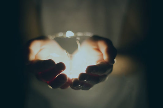 Hands holding a memorial candle in remembrance