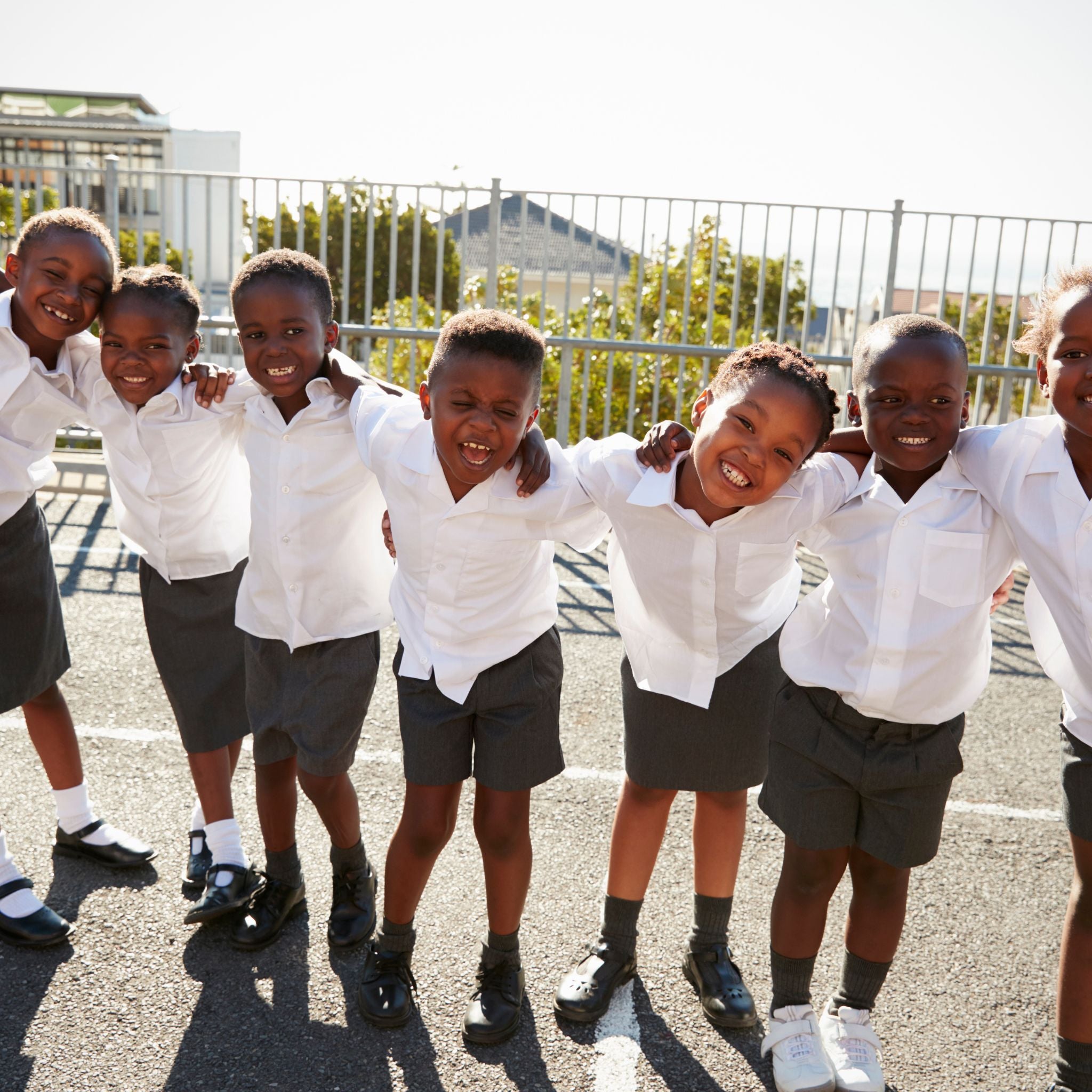 Group of smiling children in school uniforms outdoors